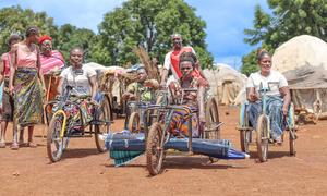 Mujeres en triciclos se abren paso por un campamento para personas desplazadas en Nigeria.