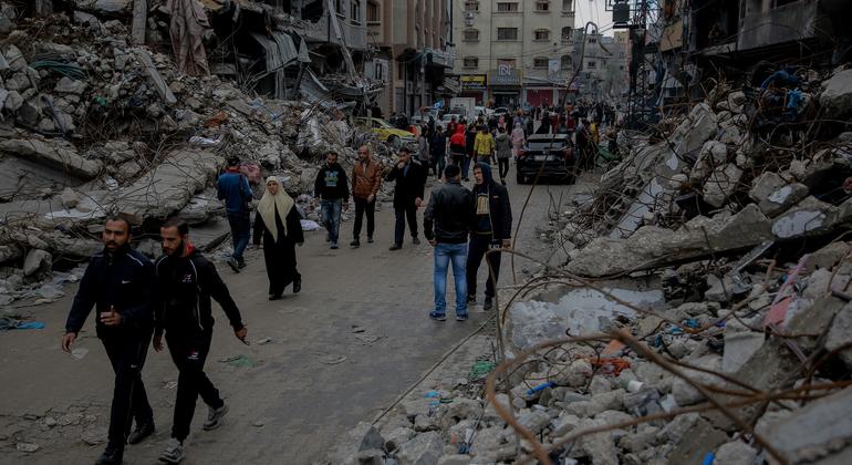 لوگ غزہ کے شمالی حصے میں بمباری سے تباہ حال اپنے گھروں کے پاس سے گزر رہے ہیں۔