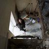 一名妇女在基辅检查她的房子，这所房子在一次空袭中受损，以致无法修复。（资料图）