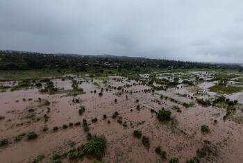 Uma visão aérea de uma paisagem rural inundada em Moçambique, destacando o impacto das mudanças climáticas e das inundações, com o envolvimento do UNICEF na resposta humanitária.