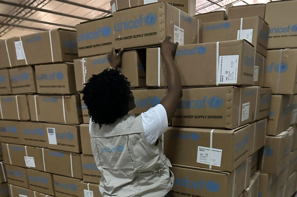 Un membre du personnel de l'UNICEF empile des boîtes d'aide d'urgence dans un entrepôt dans la province de Gaza, au Mozambique, en réponse aux inondations causées par le changement climatique.