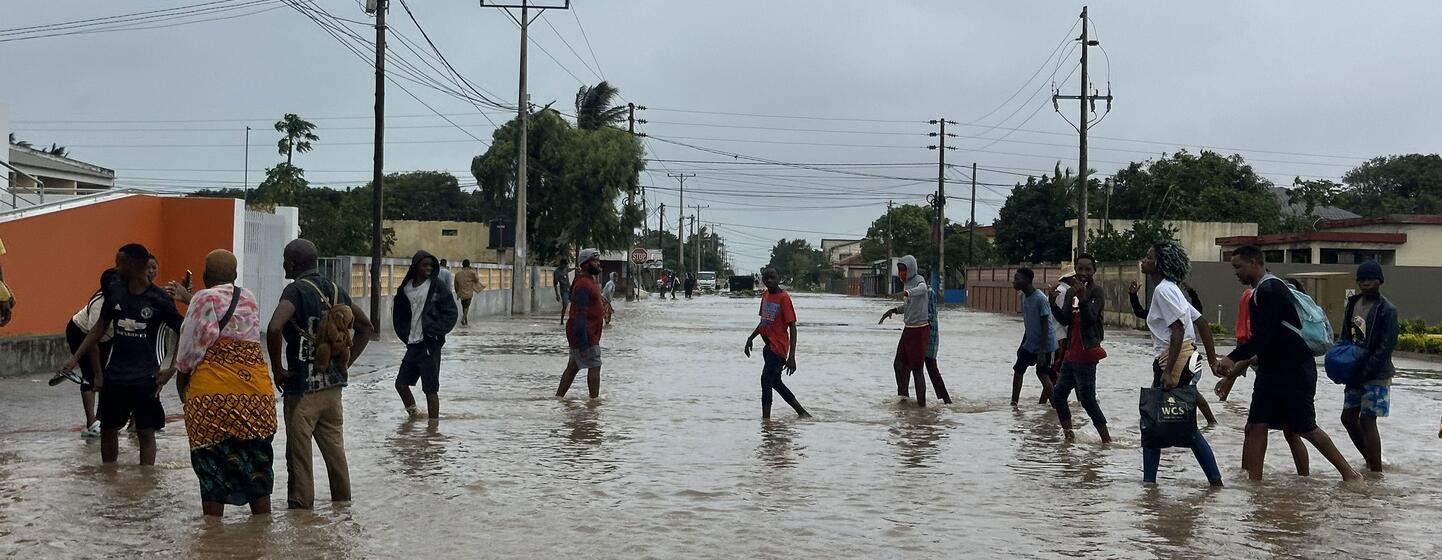 Le 19 janvier 2026, les résidents marchent dans une rue inondée à Xai Xai, dans la province de Gaza, au Mozambique, suite aux pluies extrêmes causées par le changement climatique.