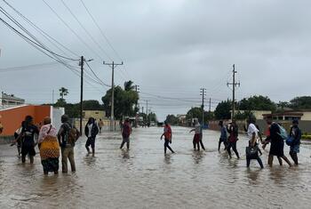 El 19 de enero de 2026, los residentes caminan por una calle inundada en Xai Xai, provincia de Gaza, Mozambique, tras las lluvias extremas causadas por el cambio climático.