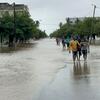 Le 19 janvier 2026, les résidents traversent une rue inondée à Xai Xai, dans la province de Gaza, au Mozambique, après des pluies extrêmes causées par le changement climatique.