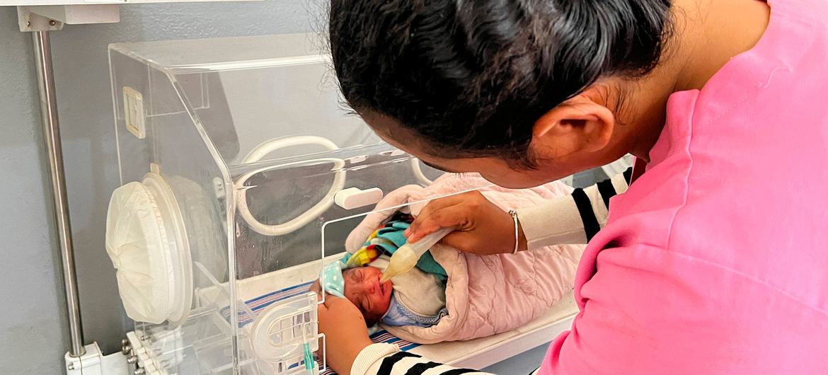  Un bébé prématuré est nourri dans une couveuse d'hôpital.