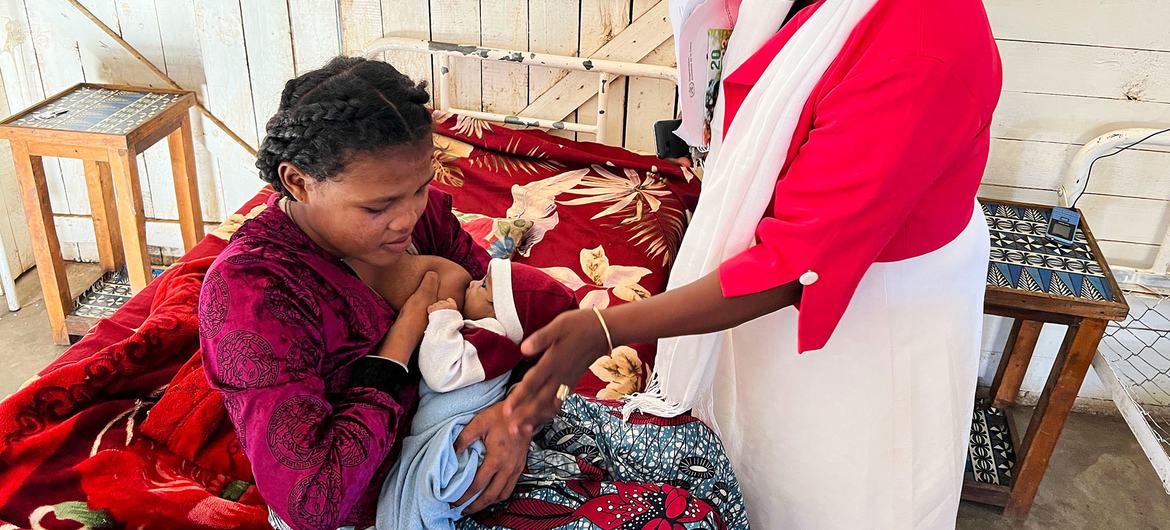 Dr. Germaine Retofa helps a new mother to breastfeed.