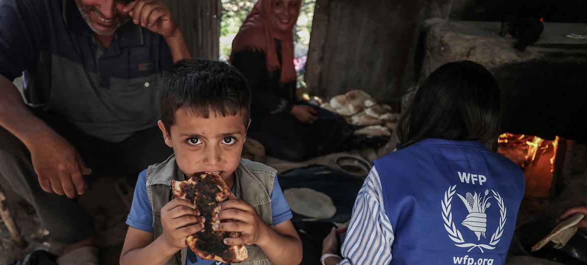 Un enfant à Gaza mange du pain cuit à partir d’ingrédients fournis par le PAM.