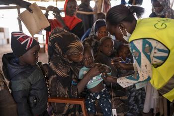 إجراء فحص لطفل يعاني من علامات سوء التغذية في مركز استقبال على الحدود بين السودان وجنوب السودان.