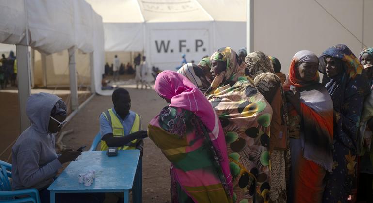Families line up to receive cash assistance. WFP provides enough cash for each person to buy daily meals while they wait to travel onwards to their final destination.