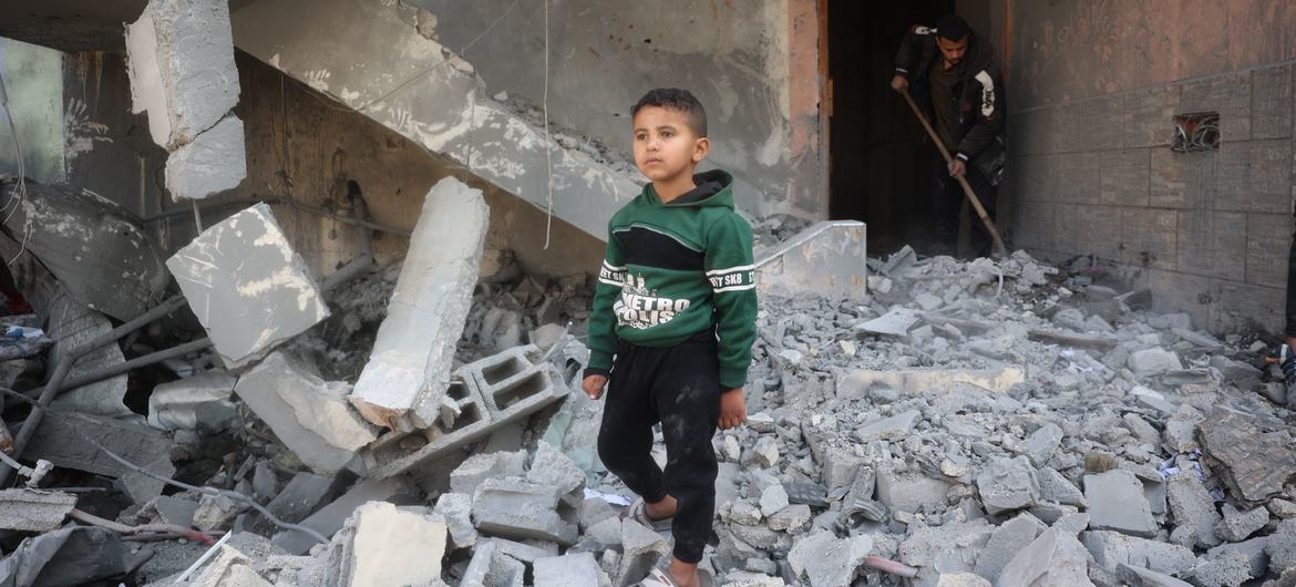 Un jeune garçon marche dans les décombres de sa maison à Al Nusirat, à Gaza.