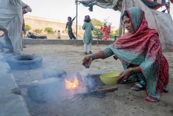 In Karachi, Pakistan, a woman burns trash to cook food causing air pollution.