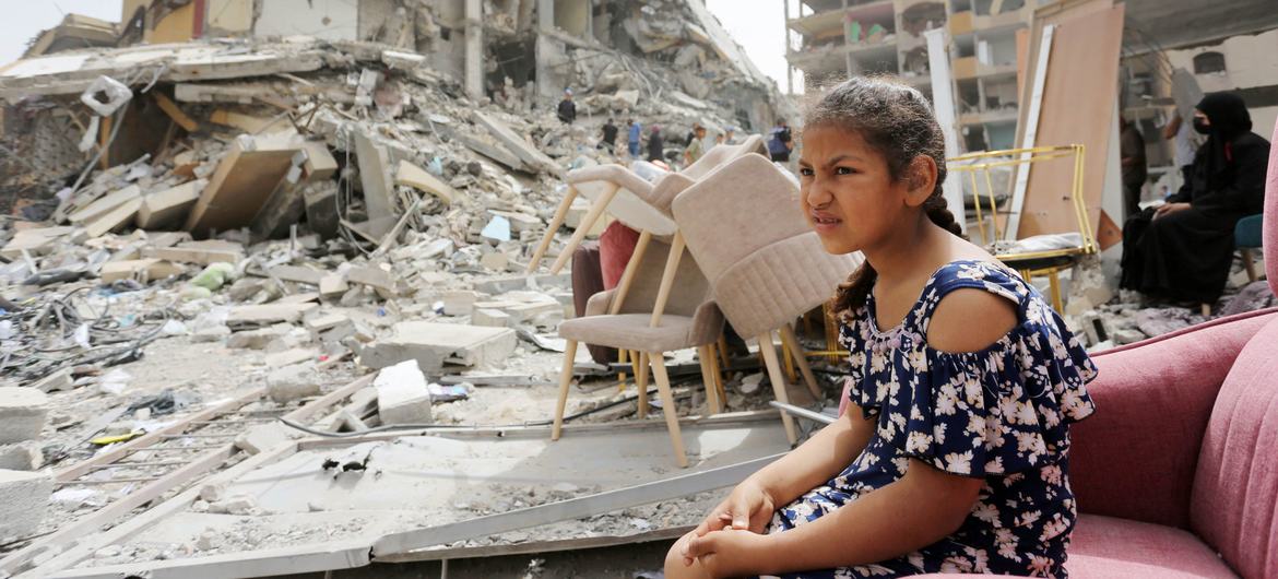 A girl sits among the rubble of destroyed buildings in Gaza.