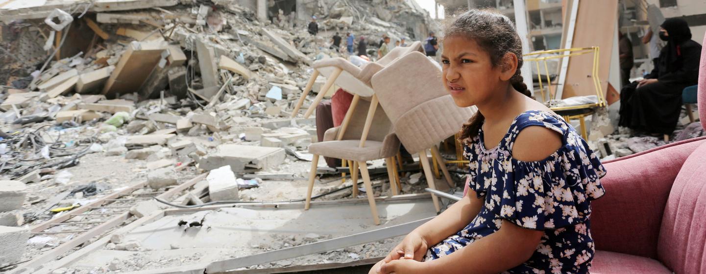 A girl sits among the rubble of destroyed buildings in Gaza.