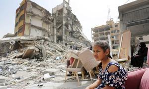 A girl sits among the rubble of destroyed buildings in Gaza.