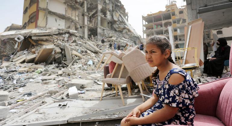 A girl sits among the rubble of destroyed buildings in Gaza.
