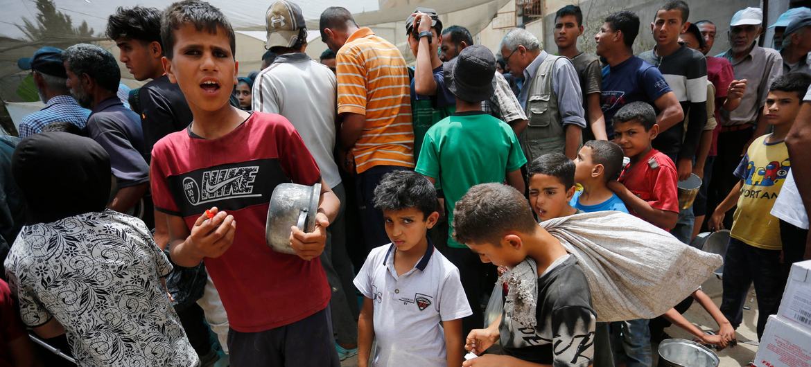 Des enfants font la queue pour obtenir de la nourriture à Gaza.