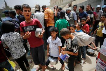 Children queue for food in Gaza.