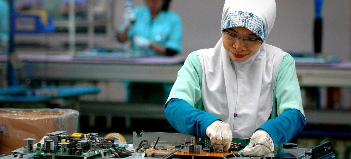 一名妇女在印度尼西亚锡卡朗的一家电子厂工作。