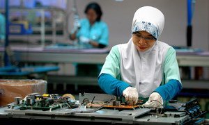 इण्डोनेशिया के सिकारांग में एक इलैक्ट्रॉनिक्स फ़ैक्टरी में काम करते हुए एक महिला.