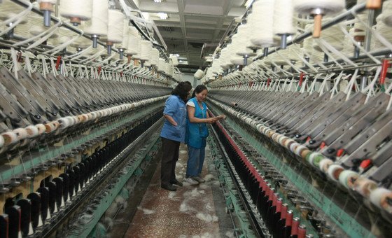 Two women check industrial looms in a rug factory in Mongolia. International rules and practices have locked developing countries into pre-pandemic responses