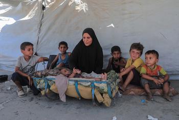 加沙地带，一户流离失所的家庭坐在帐篷前。