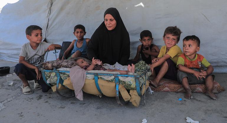 أم فلسطينية نازحة مع أطفالها الصغار، أمام خيمتهم في قطاع غزة. أم فلسطينية نازحة مع أطفالها الصغار، أمام خيمتهم في قطاع غزة.