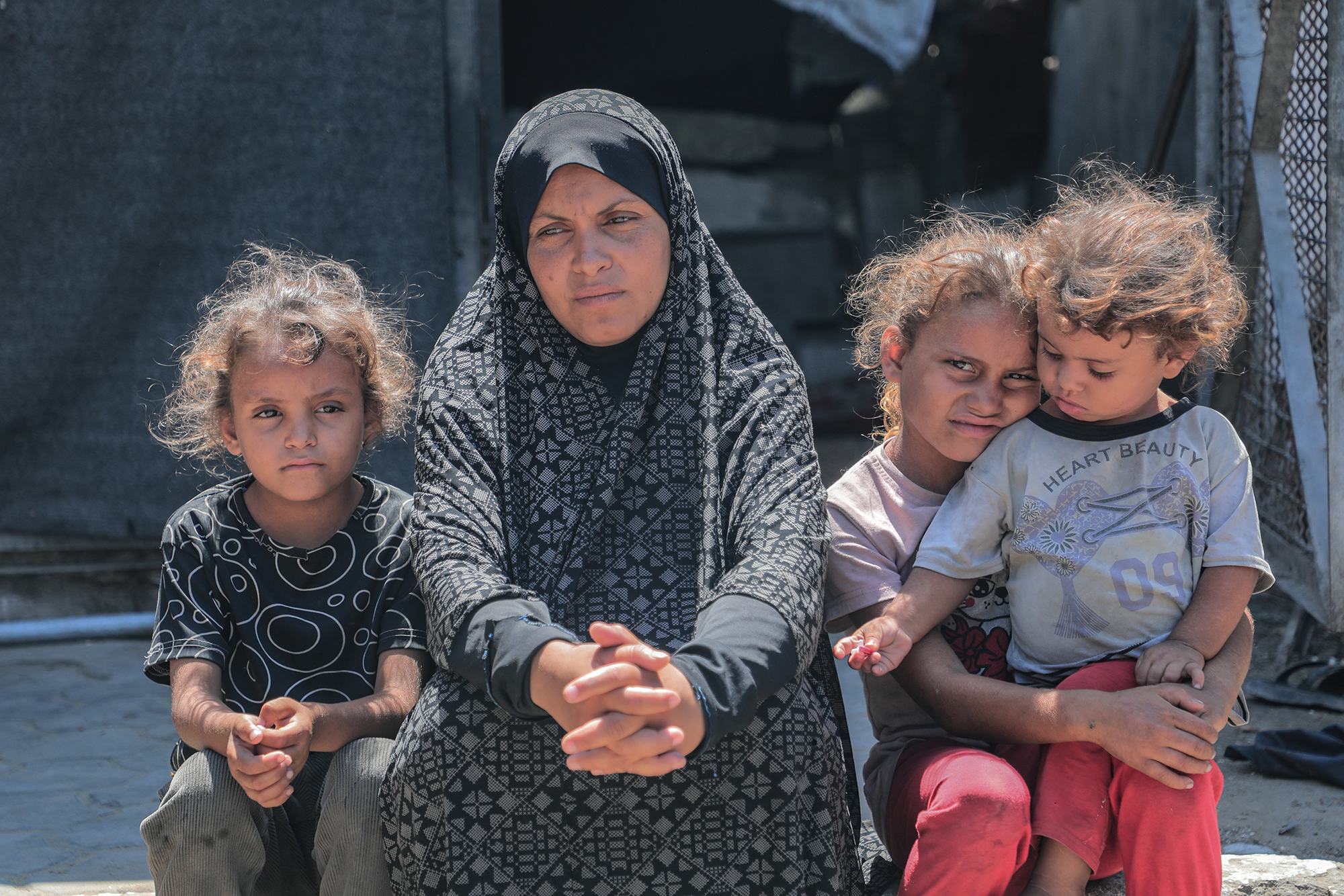 سيدة فلسطينية تجلس مع أطفالها في شمال غزة.