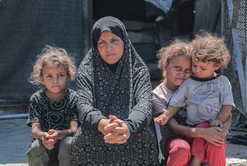 سيدة فلسطينية تجلس مع أطفالها في شمال غزة.