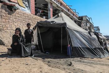 A displaced family sit outside their tent in Gaza.