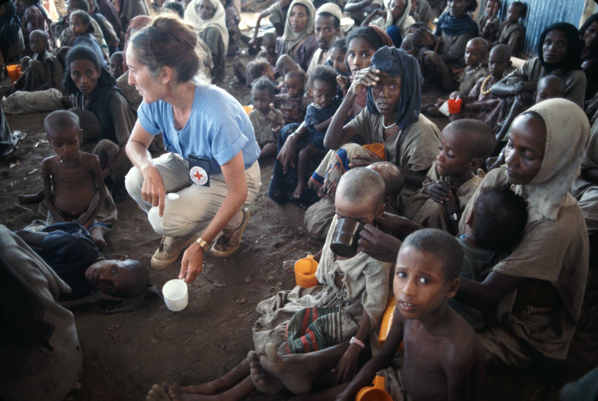 عاملة شابة في الصليب الأحمر تساعد ضحايا الجفاف في مخيم في باتي، إثيوبيا في عام 1984.