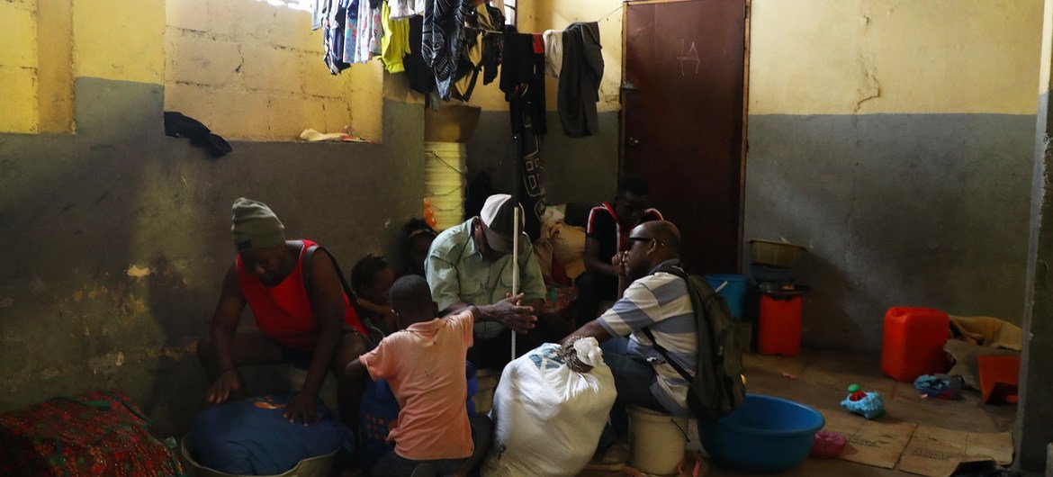 ساموئل (مرکز) و خانواده‌اش منتظر هستند تا یک مکان موقت را برای آوارگان داخلی در پورتو پرنس ترک کنند.