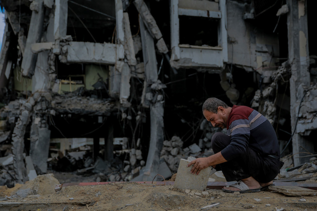 رجل يبحث بين أنقاض منزله المدمر في مدينة الشيخ زايد شمال قطاع غزة.