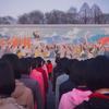 Люди стоят перед фреской в Пхеньяне, КНДР.