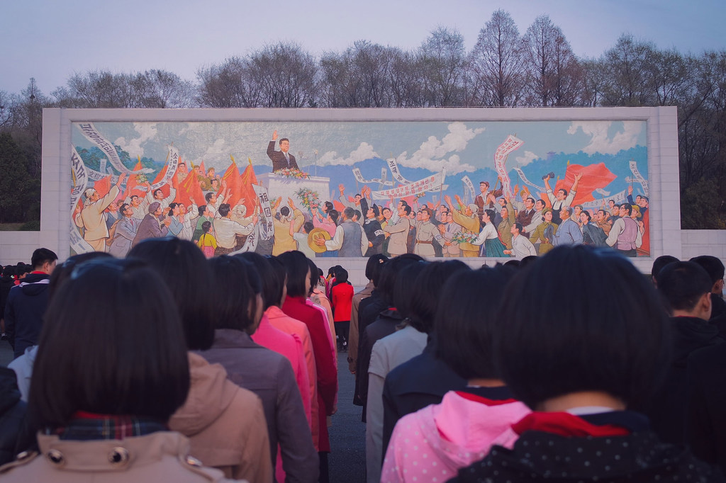 Des personnes se rassemblent devant une peinture murale à Pyongyang, en République populaire démocratique de Corée.