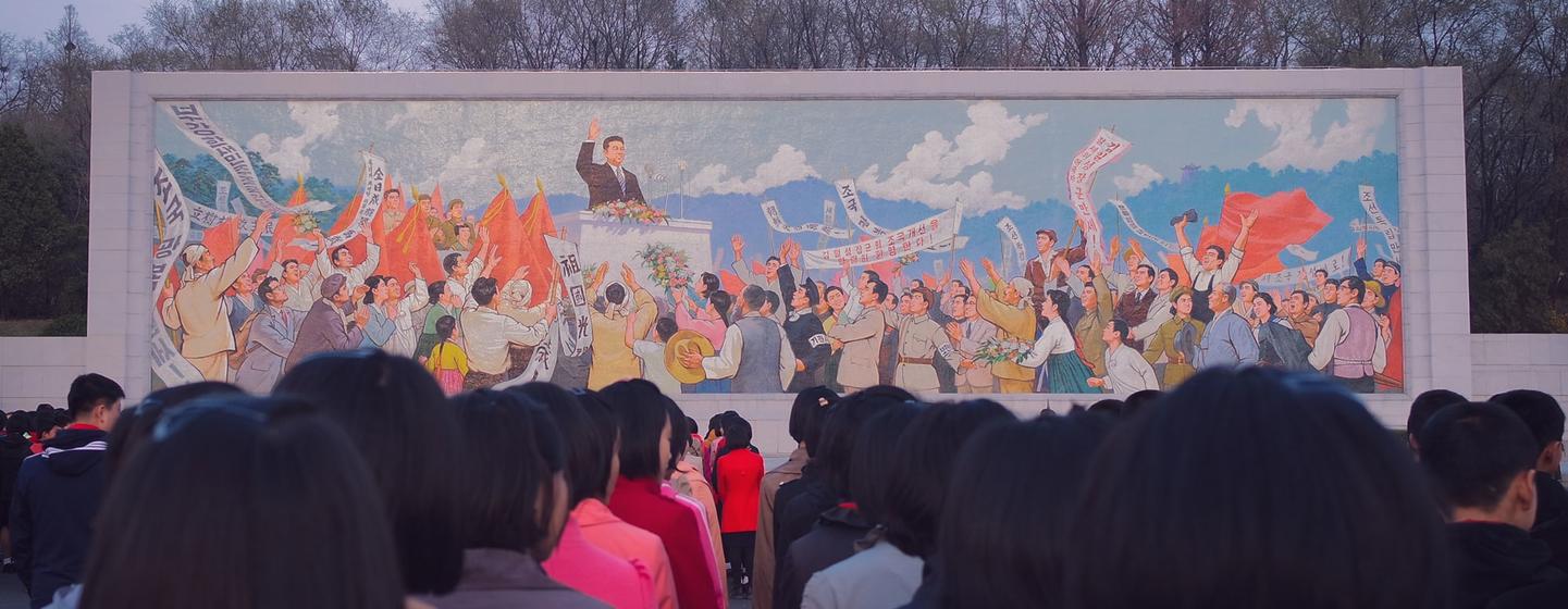 Des personnes se rassemblent devant une peinture murale à Pyongyang, en République populaire démocratique de Corée.