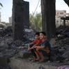 Two children sit in the rubble of what is left of their house in Rafah city, in the southern Gaza Strip.