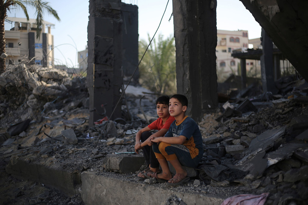 طفلان يجلسان على أنقاض ما تبقى من منزلهما في مدينة رفح، جنوبي قطاع غزة.