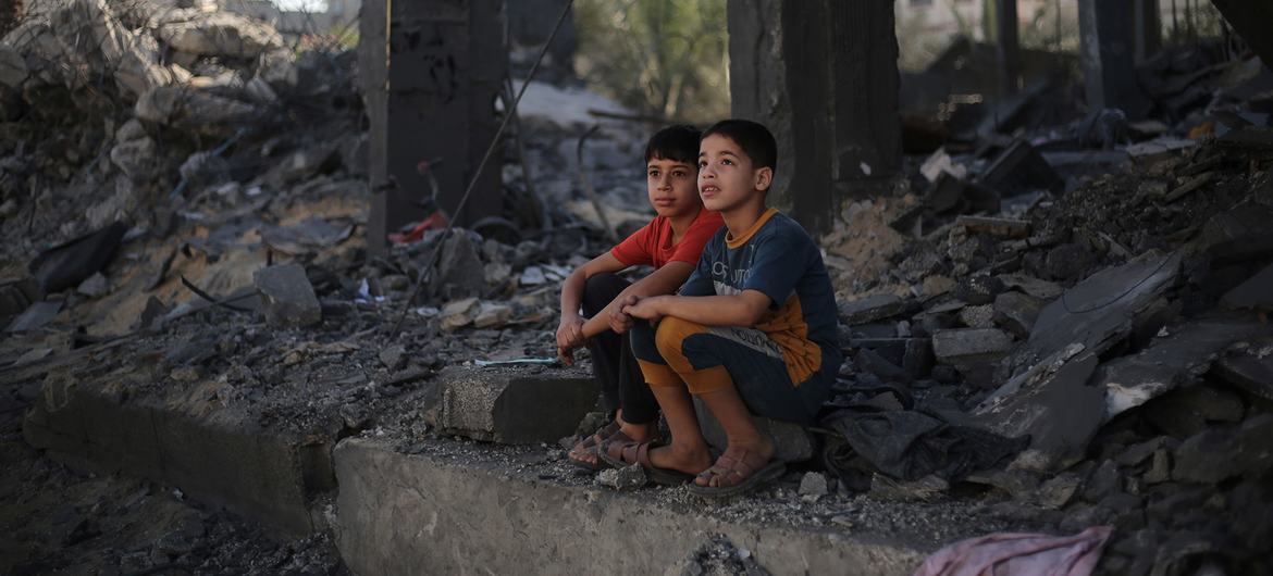 Dos niños sentados entre los escombros de lo que queda de su casa en la ciudad de Rafah, en el sur de la Franja de Gaza.