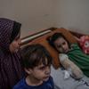 Une mère prend soin de son fils et de sa fille blessés lors d'une frappe aérienne dans la ville de Gaza.