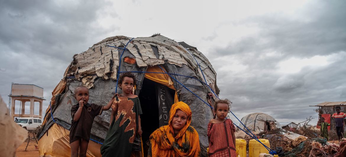 Members of a family displaced by drought and conflict rest outside their tent. Members of a family displaced by drought and conflict rest outside their tent.