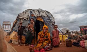 Members of a family displaced by drought and conflict rest outside their tent.