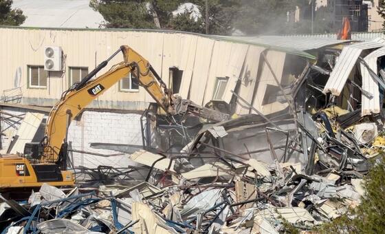 The UNRWA headquarters in East Jerusalem is demolished by heavy machinery.