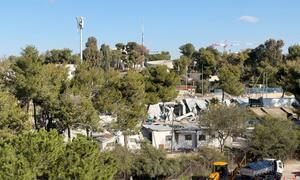 Vista aérea de la sede de la UNRWA en Jerusalén Oriental que está siendo demolida, con edificios dañados, equipos de construcción y árboles circundantes visibles.