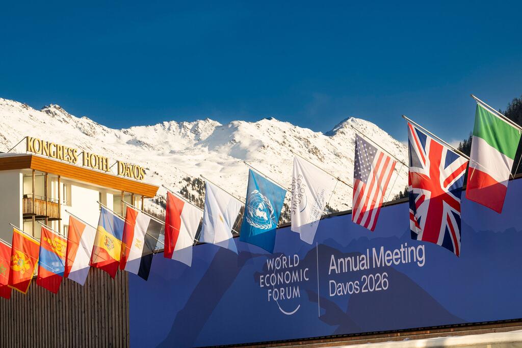 Bendera ya Mkutano wa Kila Mwaka wa Jukwaa la Uchumi Ulimwenguni 2026 huko Davos-Klosters, Uswisi, inayoonyesha bendera za kimataifa na mandhari ya milima iliyofunikwa na theluji.