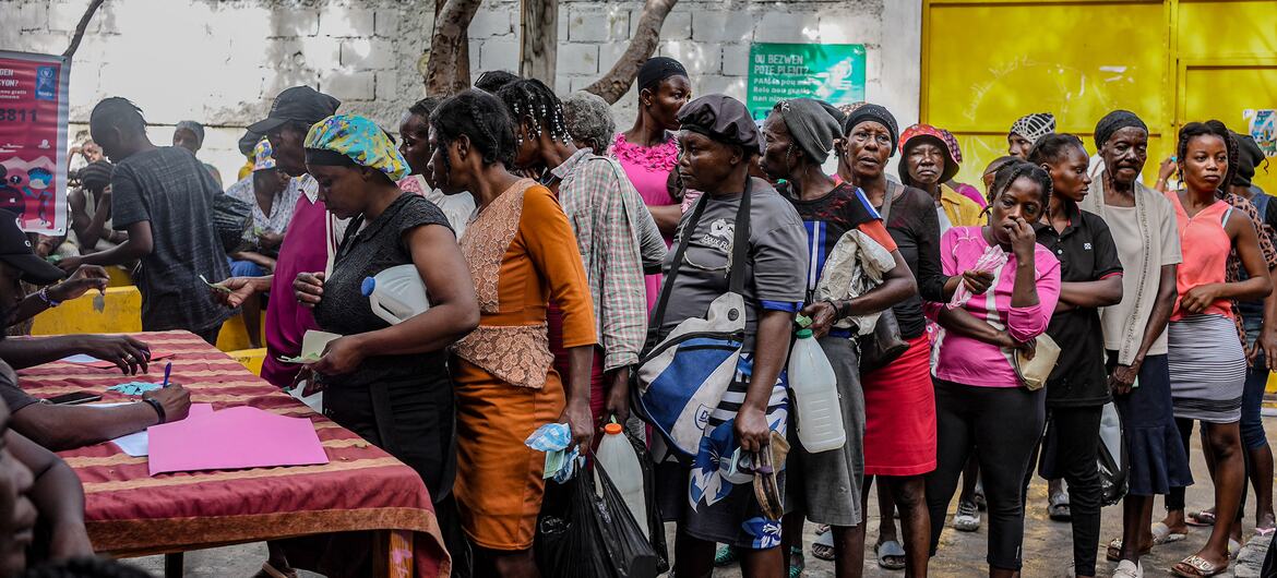 People in Haiti, Port-au-Prince, line up to receive food aid from the World Food Programme (WFP) in an area controlled by armed groups, March 2025.