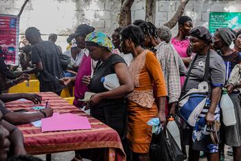 People in Haiti, Port-au-Prince, line up to receive food aid from the World Food Programme (WFP) in an area controlled by armed groups, March 2025.
