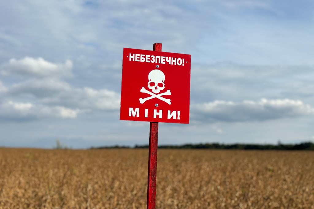 В Житомирской области Украины на убранном поле стоит красный предупреждающий знак с символом черепа и скрещенных костей.