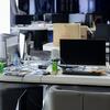 Un espace de bureau vide avec plusieurs écrans informatiques, claviers et boissons sur des bureaux, ce qui indique un centre d'escroquerie perquisitionné au Cambodge.