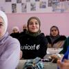 مزون المليحان سفيرة النوايا الحسنة لمنظمة اليونيسف والناشطة السورية في مجال التعليم (الوسط) تجلس على مقعد بأحد الفصول المدرسية مع عدد من الطالبات في مدرسة للفتيات في ريف دمشق، سوريا.