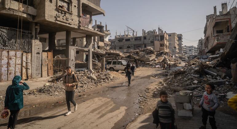 Des gens marchent dans les rues bombardées de Gaza.